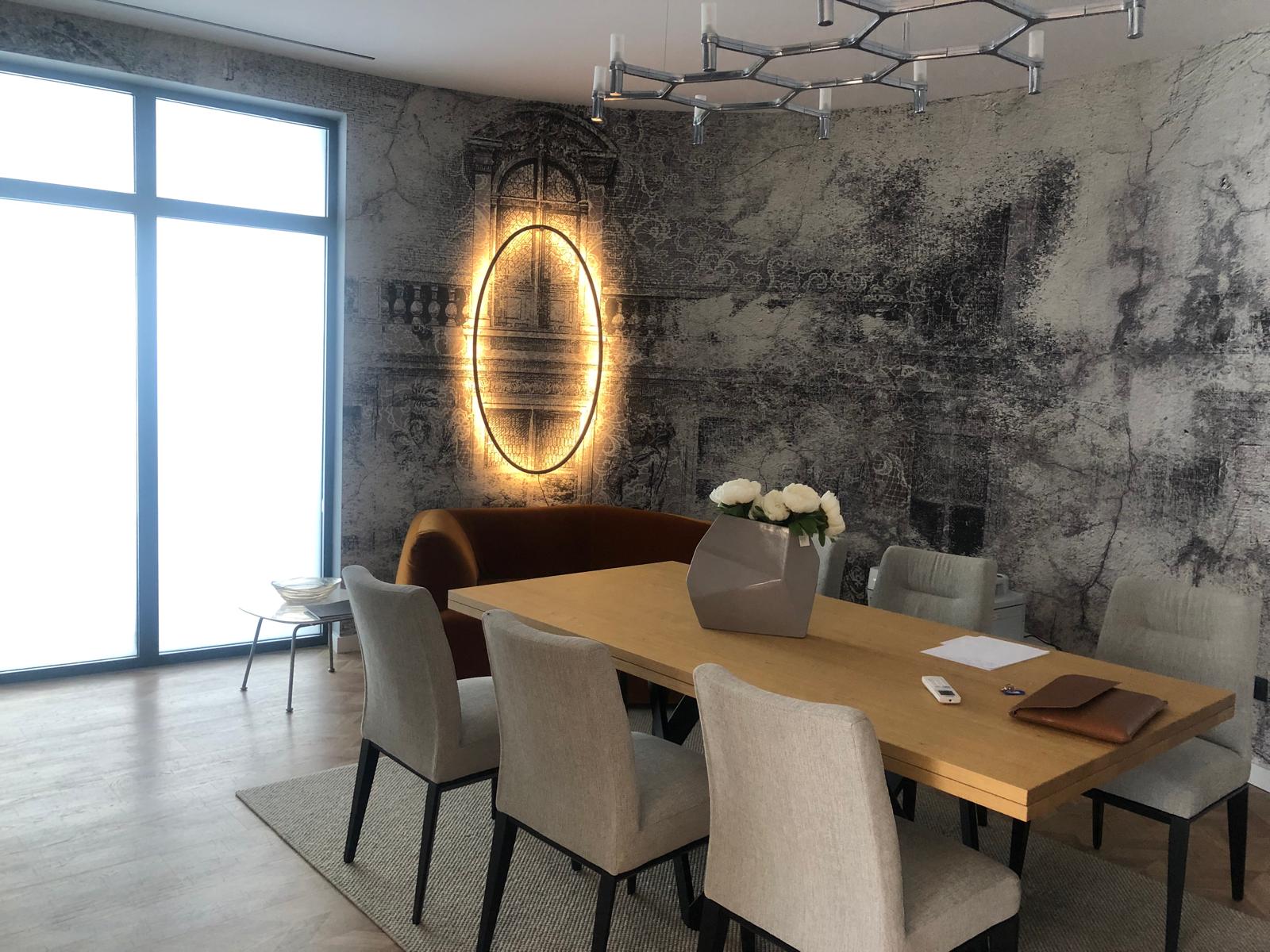 Salle à manger premium avec fresque murale et luminaire sculptural.